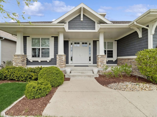doorway to property featuring covered porch and stone siding