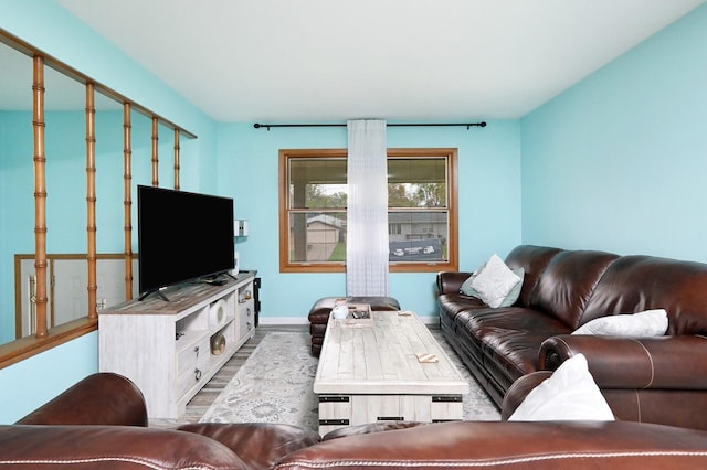 living area with baseboards and wood finished floors