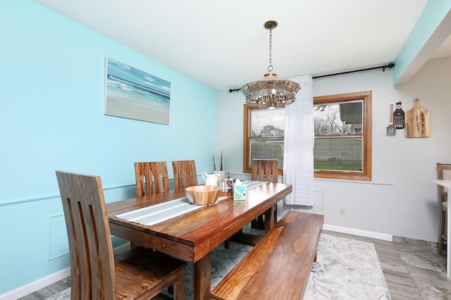 dining area with an inviting chandelier and baseboards