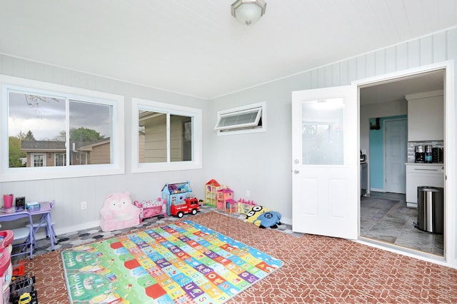 recreation room with baseboards and a wall mounted AC