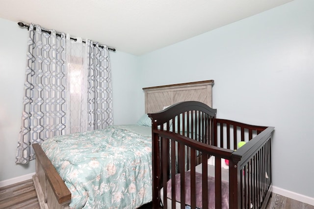 bedroom with baseboards and wood finished floors