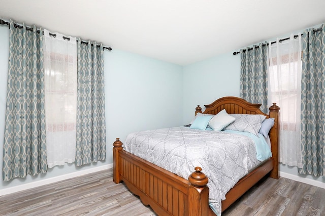 bedroom featuring baseboards and light wood-style floors