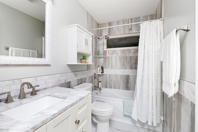 bathroom with toilet, tile walls, vanity, and shower / bath combo with shower curtain