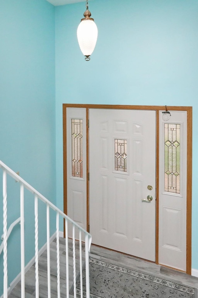 foyer entrance featuring baseboards and wood finished floors