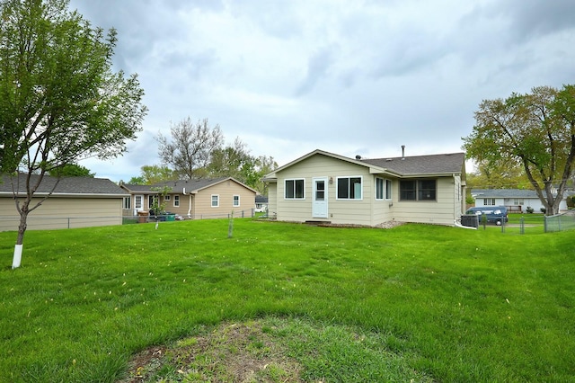 back of house featuring a yard and fence