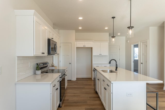 935 11th St, Waukee, IA 50263 - kitchen with appliances with stainless steel finishes, dark wood-style flooring, recessed lighting, decorative backsplash, and white cabinetry