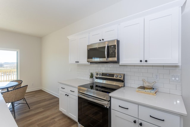 935 11th St, Waukee, IA 50263 - kitchen featuring appliances with stainless steel finishes, backsplash, wood finished floors, and light countertops