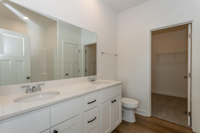 935 11th St, Waukee, IA 50263 - bathroom with double vanity, wood finished floors, and a walk in closet