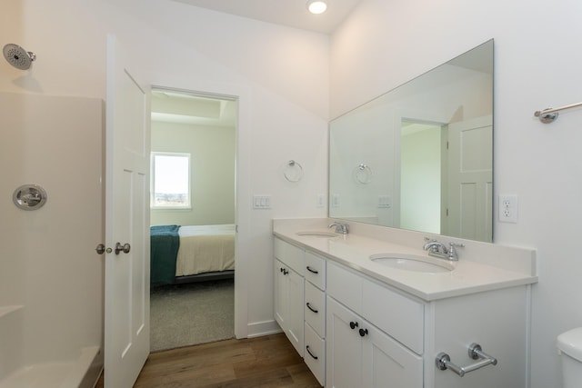935 11th St, Waukee, IA 50263 - bathroom featuring wood finished floors, double vanity, and ensuite bathroom