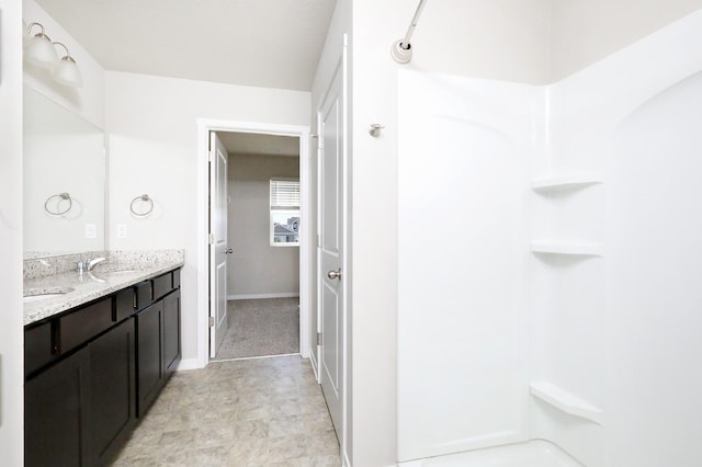 4207 NW Cedarwood Dr, Ankeny, IA 50023 - bathroom with a shower, double vanity, and baseboards