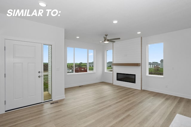 955 11th St, Waukee, IA 50263 - unfurnished living room with plenty of natural light, baseboards, light wood-type flooring, and recessed lighting