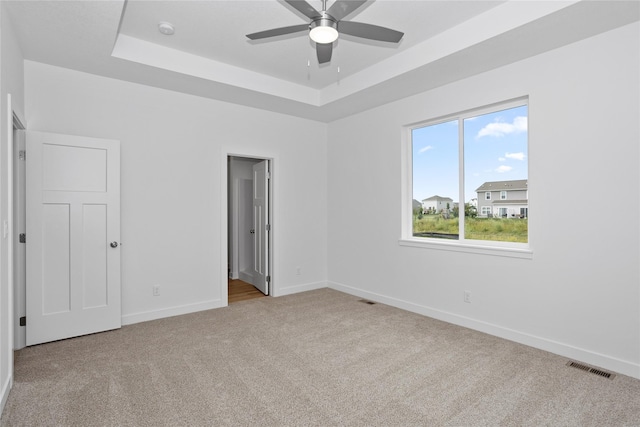 955 11th St, Waukee, IA 50263 - unfurnished bedroom with a tray ceiling, carpet flooring, baseboards, and ensuite bath