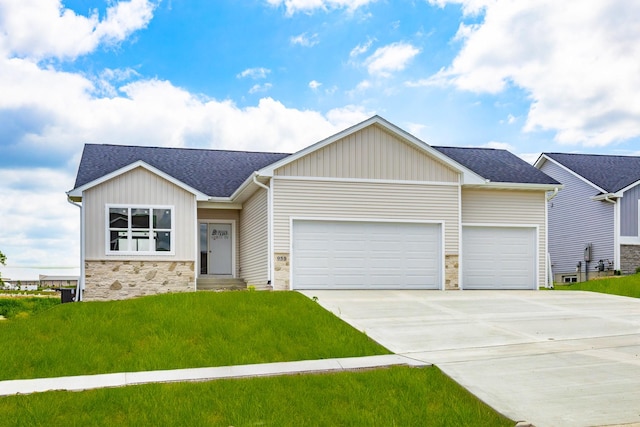 955 11th St, Waukee, IA 50263 - view of front of home featuring an attached garage, stone siding, board and batten siding, and driveway