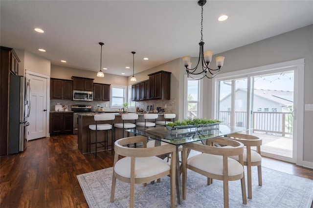 dining area with a chandelier, recessed lighting, and dark wood finished floors