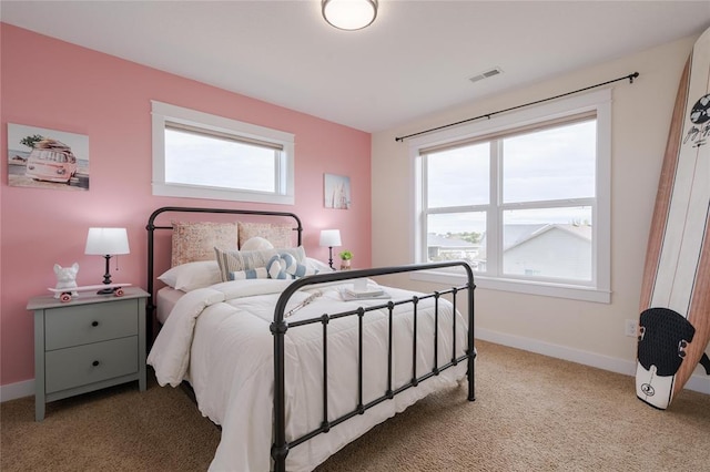 bedroom with light colored carpet, baseboards, visible vents, and multiple windows