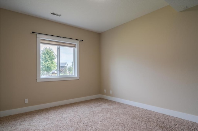 empty room featuring carpet, baseboards, and visible vents