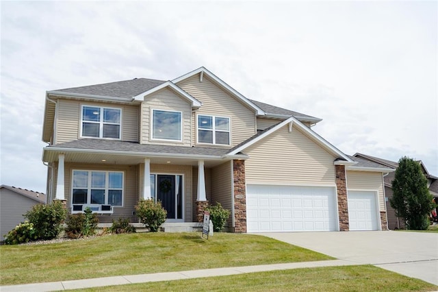 craftsman house with a front lawn, roof with shingles, driveway, and a garage