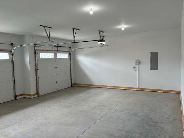 garage featuring electric panel, baseboards, and a garage door opener