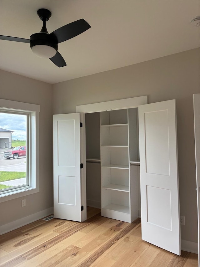 unfurnished bedroom featuring a closet, visible vents, light wood-style flooring, a ceiling fan, and baseboards