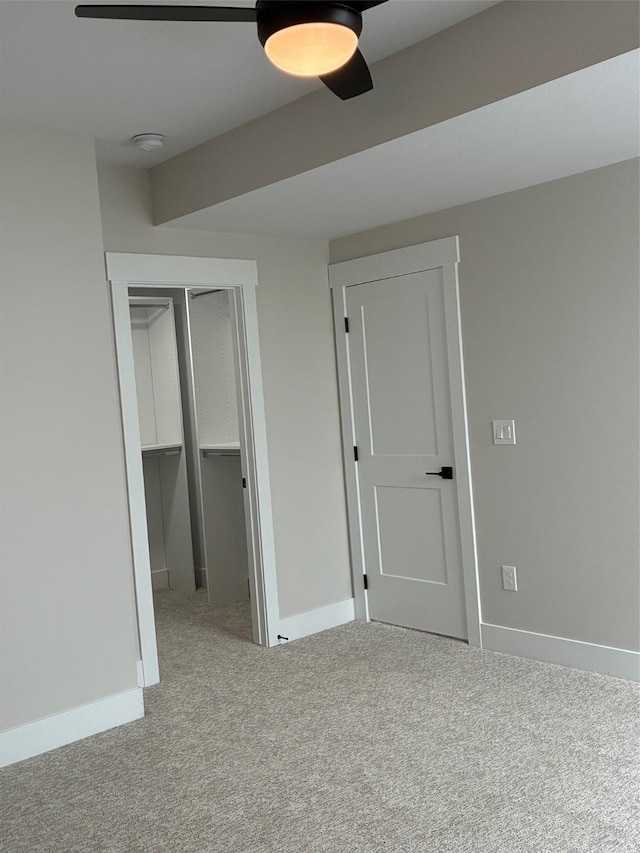 unfurnished bedroom with carpet flooring, a closet, baseboards, and ceiling fan