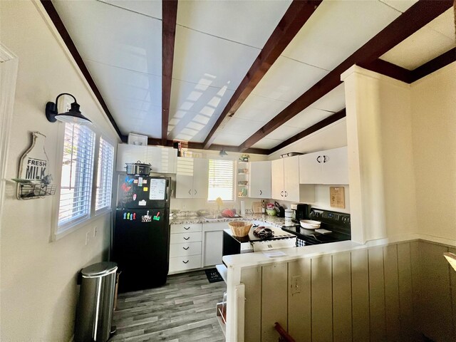 2216 Lay St, Des Moines, IA 50317 - kitchen featuring black appliances, plenty of natural light, wood finished floors, and white cabinets