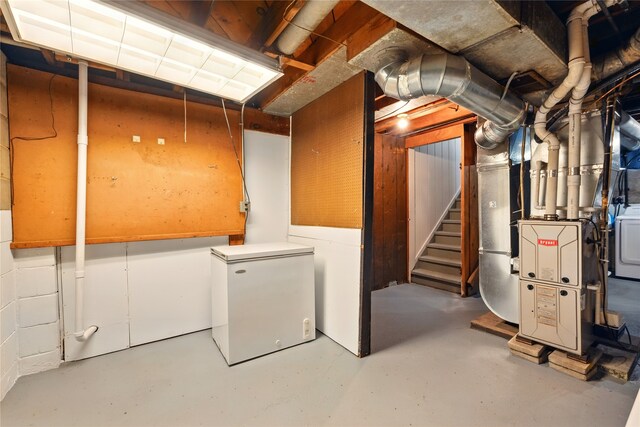 2216 Lay St, Des Moines, IA 50317 - unfinished below grade area with fridge, stairway, and heating unit