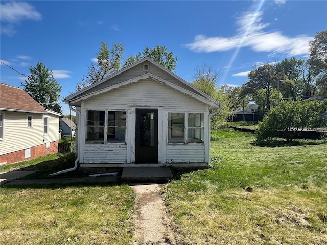 view of front of house with a sunroom and a front lawn