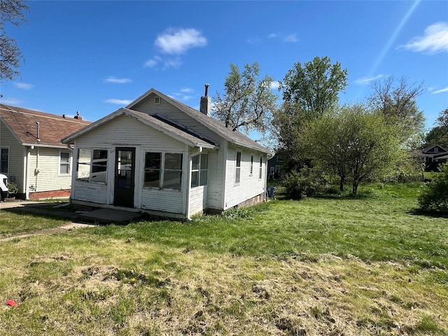 back of property featuring a lawn