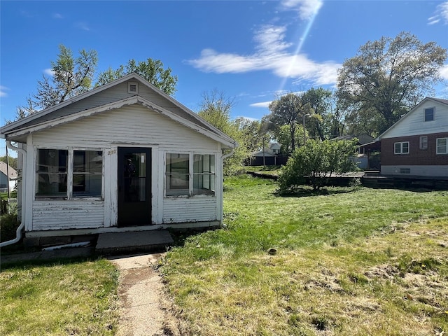 view of front of property featuring a front yard and a sunroom