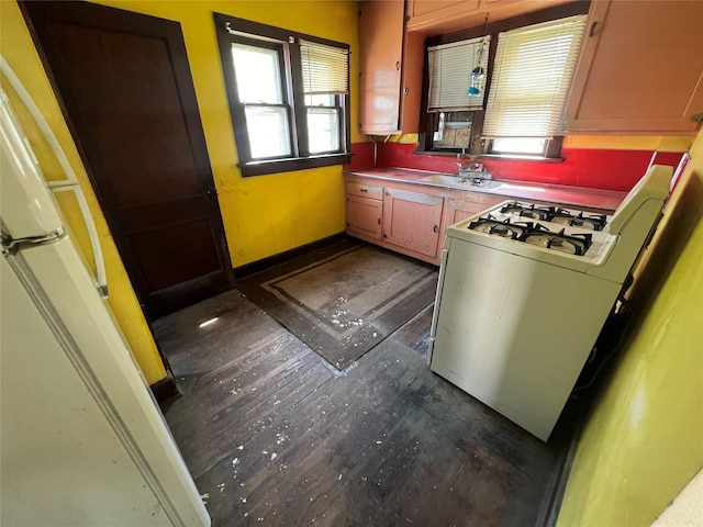 kitchen with water heater, white gas stove, dark wood-style floors, and a sink