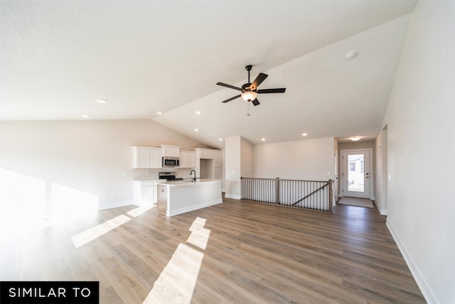 unfurnished living room featuring a ceiling fan, baseboards, light wood finished floors, and high vaulted ceiling