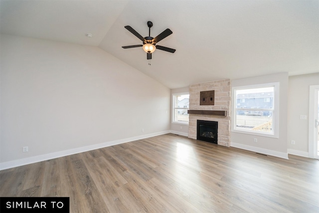 unfurnished living room featuring lofted ceiling, wood finished floors, a fireplace, a ceiling fan, and baseboards