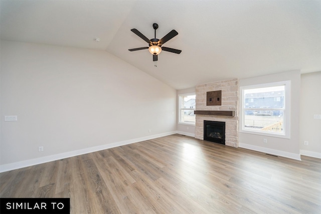 unfurnished living room with light wood finished floors, a fireplace, visible vents, ceiling fan, and vaulted ceiling