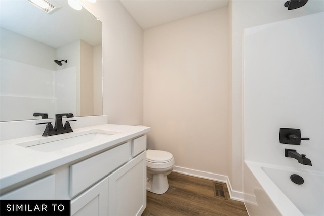 bathroom with toilet, vanity, visible vents, and wood finished floors