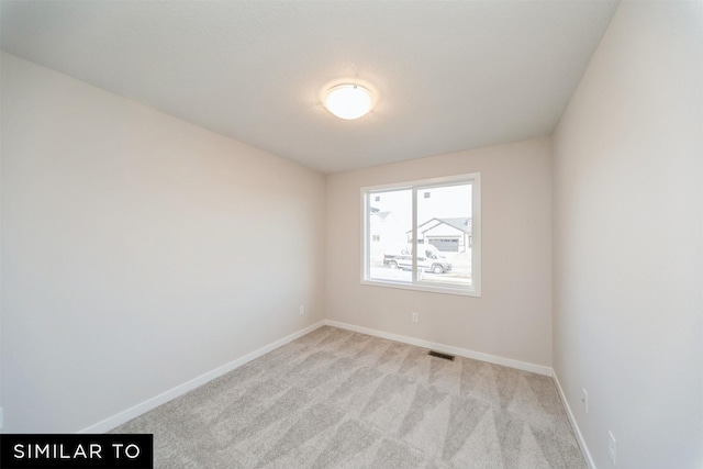 unfurnished room with light colored carpet, visible vents, and baseboards