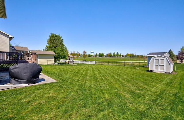 view of yard with an outbuilding, fence, and a storage unit