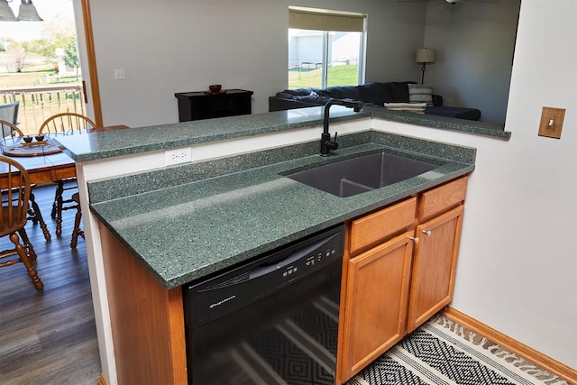 kitchen featuring a sink, brown cabinetry, dishwasher, open floor plan, and dark wood-style floors