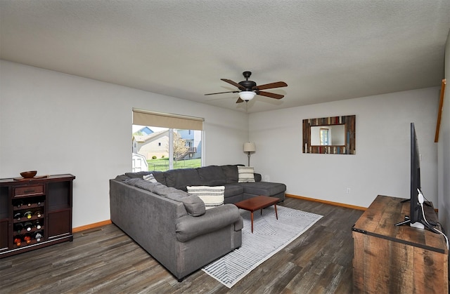 living area featuring baseboards, a ceiling fan, and dark wood finished floors