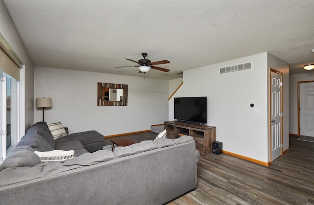 living area with a textured ceiling, visible vents, ceiling fan, dark wood-style floors, and baseboards