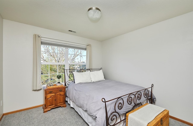 bedroom featuring light colored carpet, visible vents, and baseboards