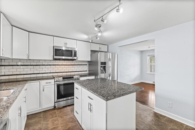 525 SW Walnut St, Ankeny, IA 50023 - kitchen featuring appliances with stainless steel finishes, a center island, tasteful backsplash, and white cabinetry
