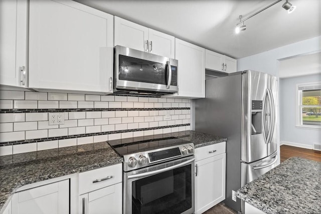 525 SW Walnut St, Ankeny, IA 50023 - kitchen featuring dark wood-style flooring, dark stone counters, white cabinets, tasteful backsplash, and appliances with stainless steel finishes