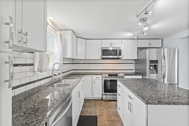 525 SW Walnut St, Ankeny, IA 50023 - kitchen featuring dark stone countertops, a sink, white cabinetry, backsplash, and appliances with stainless steel finishes