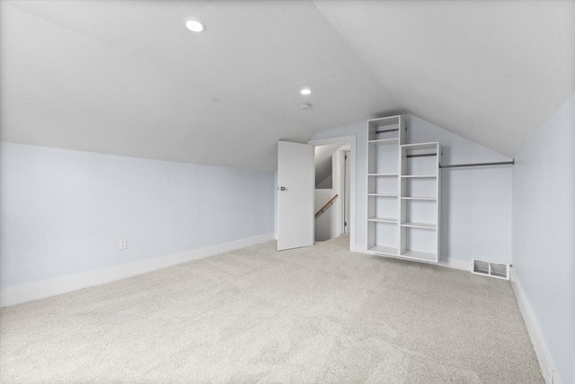 525 SW Walnut St, Ankeny, IA 50023 - additional living space with light carpet, visible vents, baseboards, vaulted ceiling, and recessed lighting