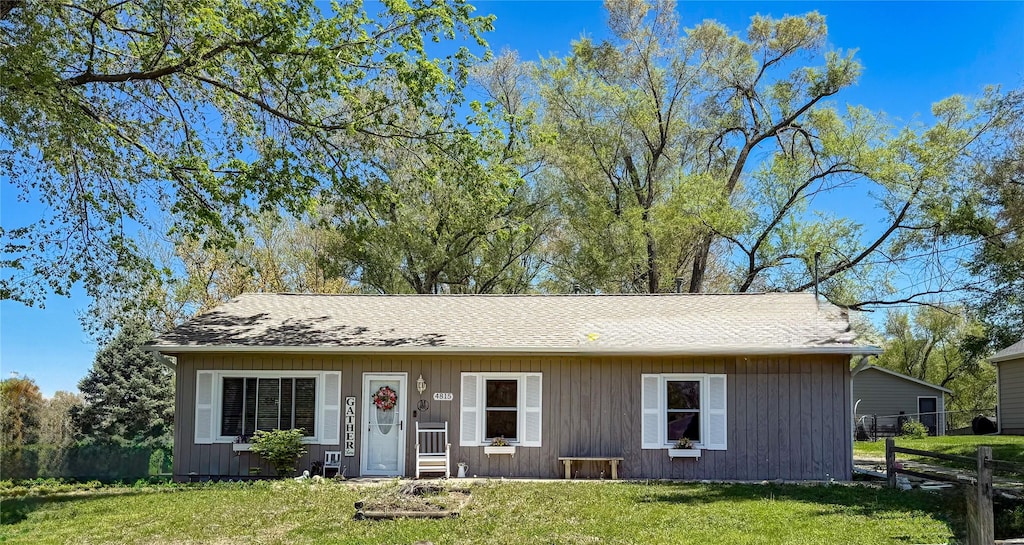 4815 NW 53rd Ct, Des Moines, IA 50310 - view of front of home featuring a front yard, a shingled roof, and fence
