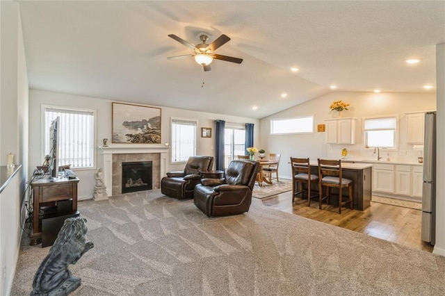 2708 NW Boulder Point Pl, Ankeny, IA 50023 - living area featuring a wealth of natural light, a tiled fireplace, vaulted ceiling, and ceiling fan