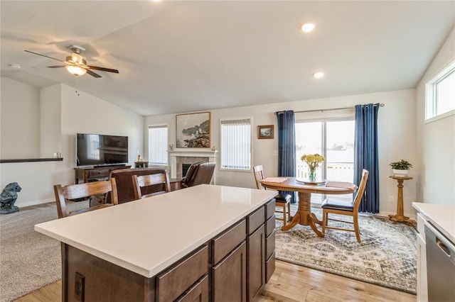 2708 NW Boulder Point Pl, Ankeny, IA 50023 - kitchen with lofted ceiling, a ceiling fan, stainless steel dishwasher, open floor plan, and a fireplace