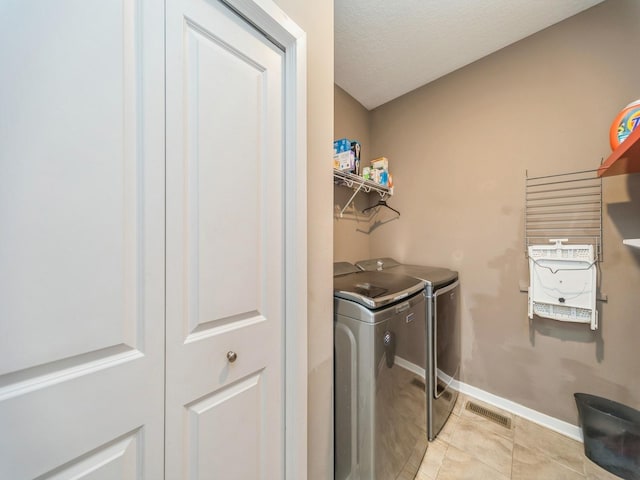 laundry room with laundry area, light tile patterned floors, baseboards, visible vents, and separate washer and dryer