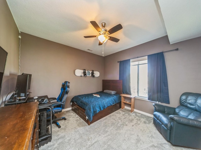 carpeted bedroom with visible vents, baseboards, and a ceiling fan