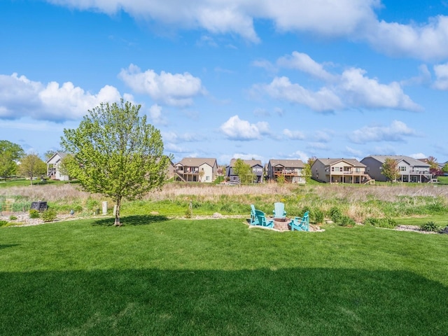 view of yard featuring an outdoor fire pit and a residential view